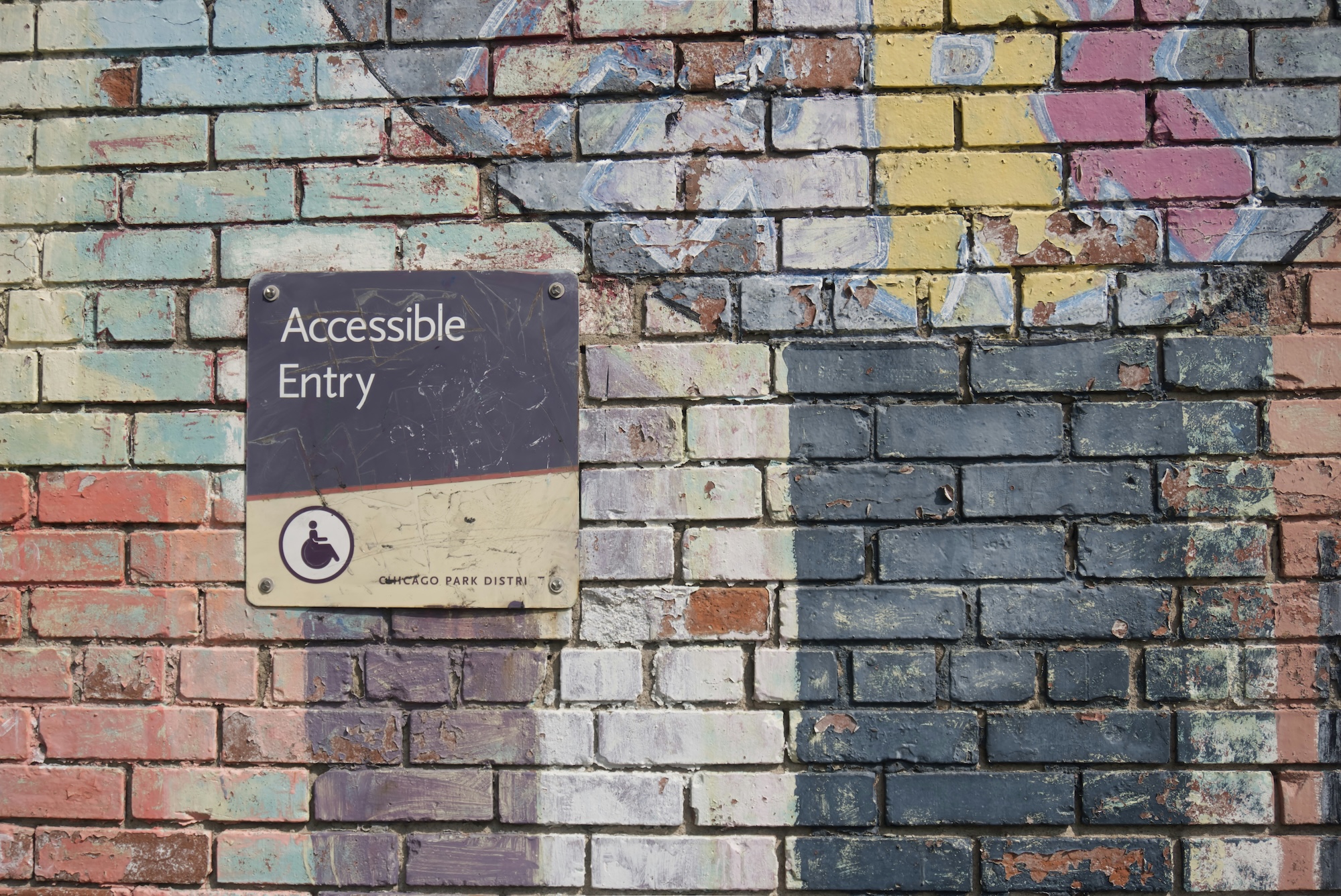 Accessible entry sign on a brick wall